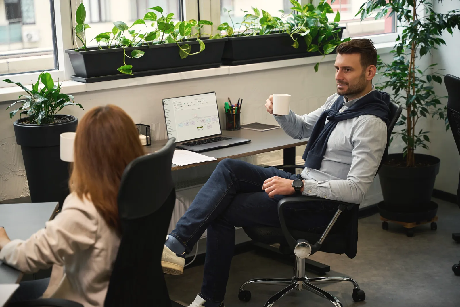Zwei Kollegen in einer entspannten Kaffeepause im hellen Büro